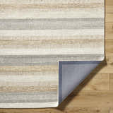 Close-up of the hand-tufted Touca Area Rug. Wool rug with ash, light silver, silver gray, and warm gray stripes. Fold