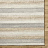 Close-up of the hand-tufted Touca Area Rug. Ash, light silver, and warm gray stripes on a 100% wool rug. Corner