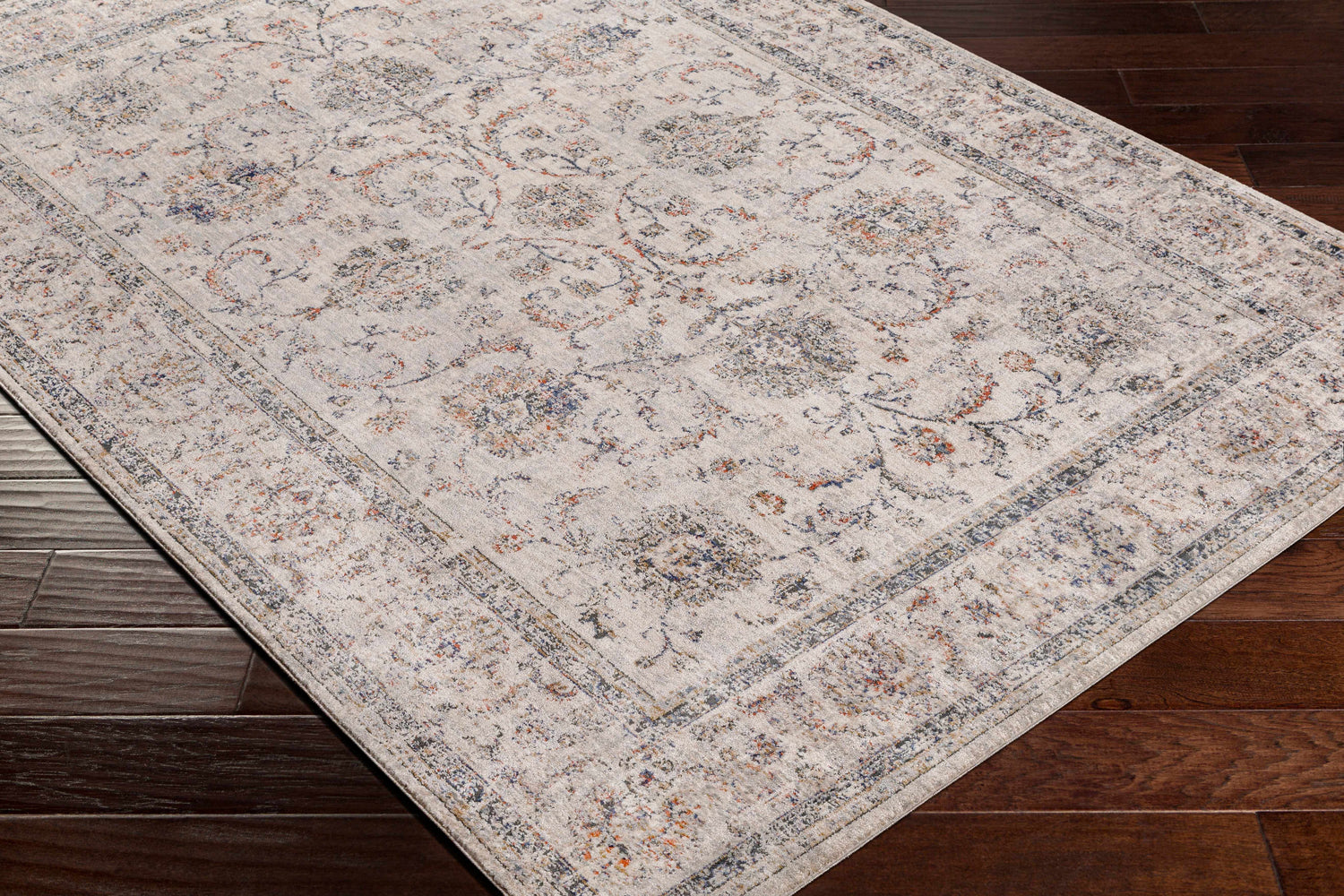 Close-up of the Temelec Area Rug showing its beige, burnt orange, and charcoal traditional floral pattern and texture. Corner