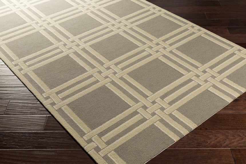 Close-up of the Templeton Area Rug showing a gray and ivory geometric pattern on dark wood floors. Corner