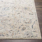 Close up of Ternate Area Rug showing cream, navy, and brick red details on a dark wood floor. Front