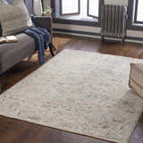 Living room scene with a cream Ternate Area Rug, gray sofa, and dark wood floors. Roomscene-Rectangle