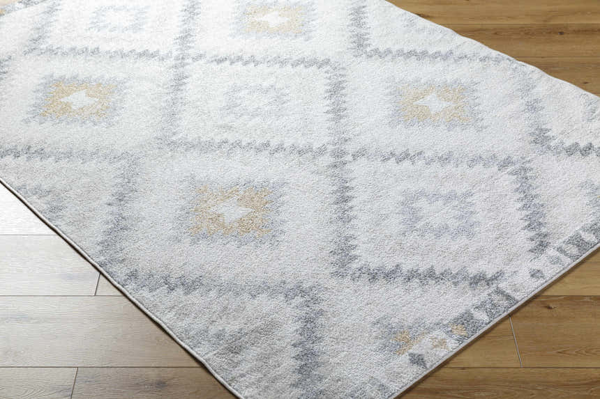 Close-up of the Tyipa Area Rug: a Southwestern style rug with charcoal, cream, gray and mustard geometric pattern. Corner