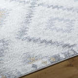Close-up of the Tyipa Area Rug showing its charcoal, cream, gray, and mustard Southwestern pattern and soft texture. Texture