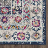 Close-up of the Tigrim Beige 2306 Area Rug. Features a floral, bohemian pattern in beige, ivory, navy, pink, and yellow. Corner