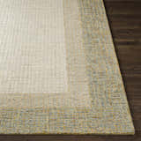 Close-up of the hand tufted Tandayag Area Rug. Cream, light beige, and dusty sage wool rug with a striped design. Front