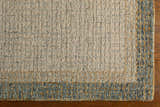 Close-up of the hand-tufted Tandayag Area Rug. Features cream, sage, and tan wool with a contemporary striped design. Corner