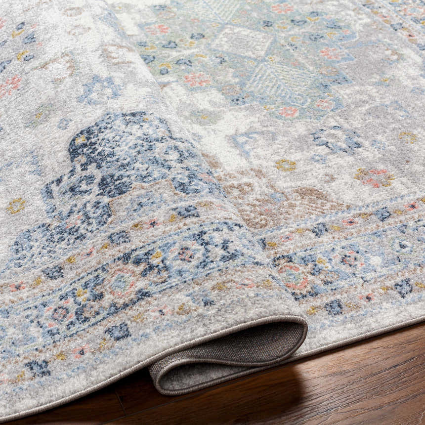 Close-up of the Tana Washable Area Rug in Arctic Stone, showing its traditional floral pattern and soft texture. Fold