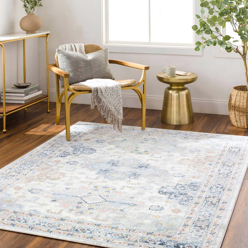 Living room scene with a Tana Washable Area Rug in arctic stone, gold accents, and a light, airy feel. Roomscene-Rectangle