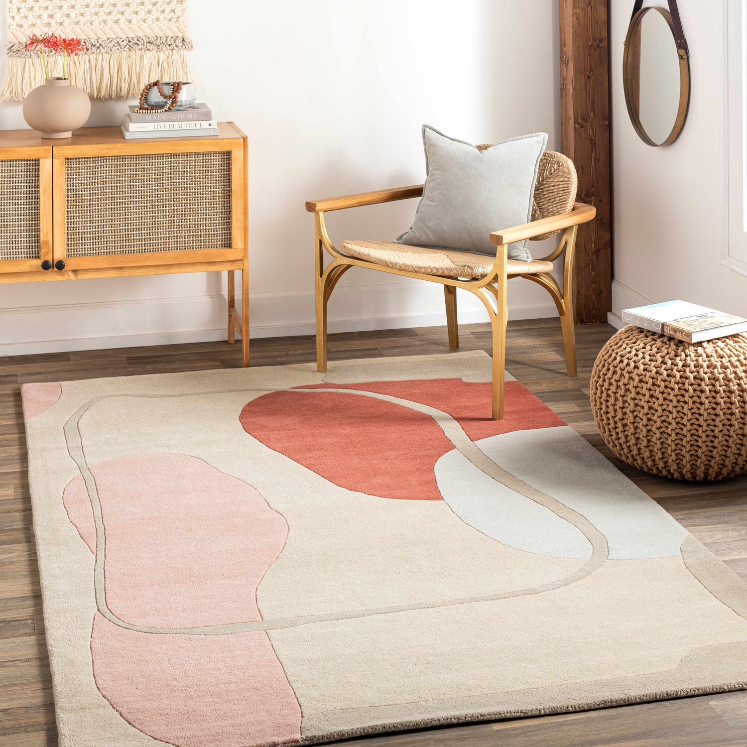 Living room scene with a Tomingad Area Rug featuring geometric shapes in brick red, dusty pink, and oatmeal. Mid-century modern style. Roomscene-Rectangle