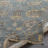 Close-up of the hand-knotted Toquerville Premium Rug. Aqua, charcoal, and wheat colors with a traditional floral pattern. Fold