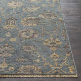 Close-up of the hand-knotted Toquerville Premium Rug. Aqua rug with charcoal, oatmeal, and wheat floral pattern on dark wood floor. Front