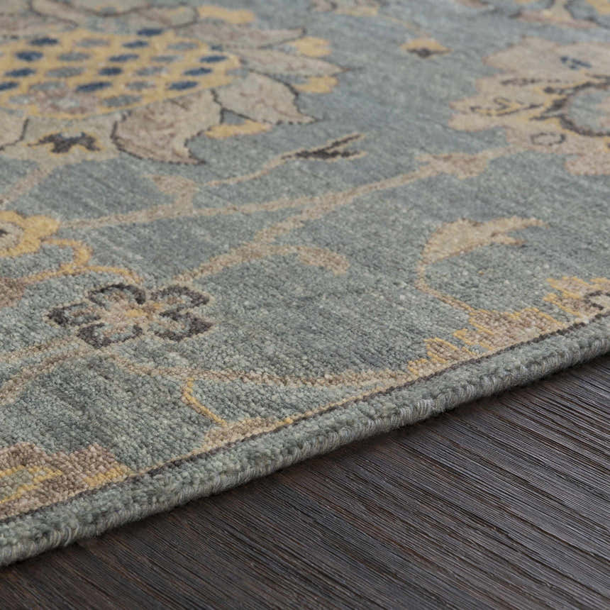 Close-up of the Toquerville Premium Rug. Aqua, charcoal, and oatmeal floral pattern on a hand-knotted viscose rug. Texture