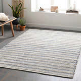 Living room scene with a beige and denim striped Totolan Area Rug, bench, plants, and natural light. Roomscene-Rectangle