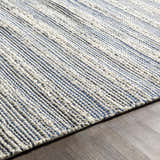 Close up of the hand woven Totolan Area Rug. Beige jute rug with denim and black stripes. Texture