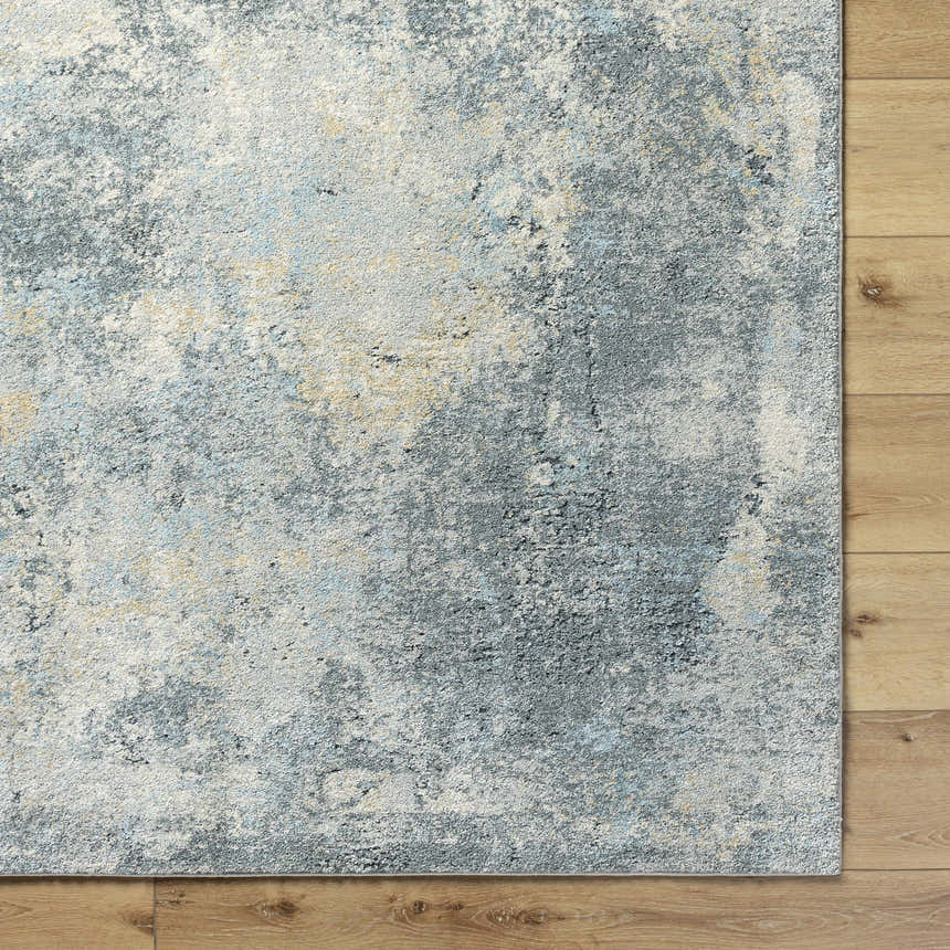 Close-up of the Adsila Teal Blue rug showing its gray, blue, and tan abstract pattern and plush texture. Corner