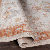 Close-up of the Tsawwassen Thick Luxe Area Rug showing brick red, light beige, and charcoal oriental pattern. Fold