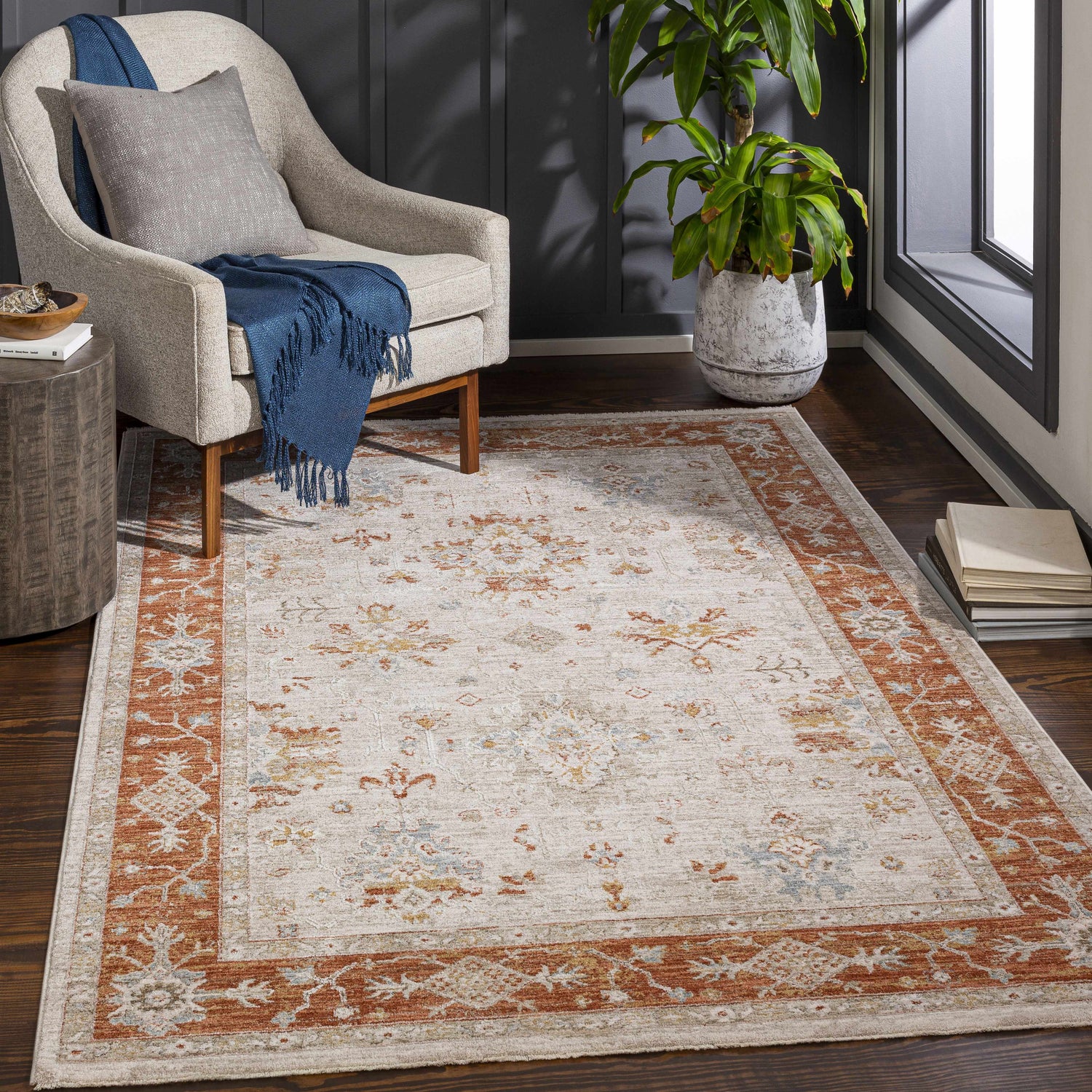 Living room scene with Tsawwassen Thick Luxe Area Rug in brick red and beige, styled with a chair, side table, and plant. Roomscene-Rectangle