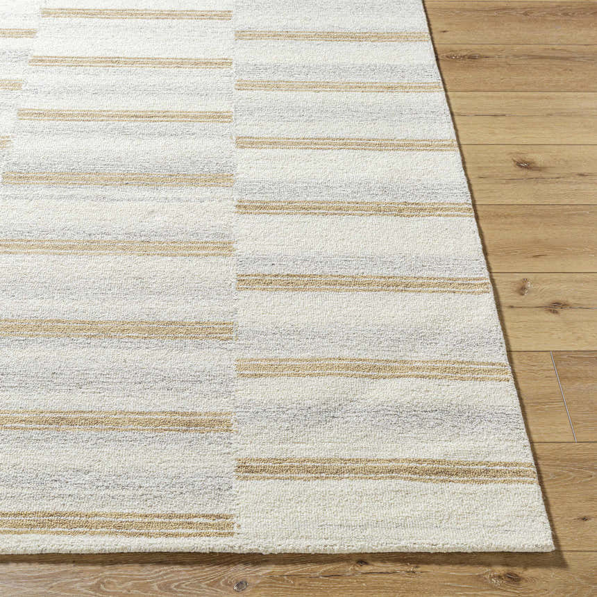 Close-up of the Toren Broken-Striped Area Rug. Hand-tufted wool rug in ash, pearl, and prairie dust on wood floor. Front