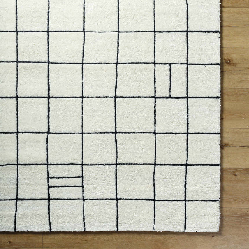 Close-up of the Tuuka Pearl Area Rug. Hand-tufted cotton and wool rug with a pearl background and black geometric grid pattern. Swatch
