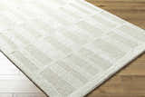 Close up of the Teige Light Silver Area Rug showing its textured, geometric block pattern and soft, neutral colors. Corner