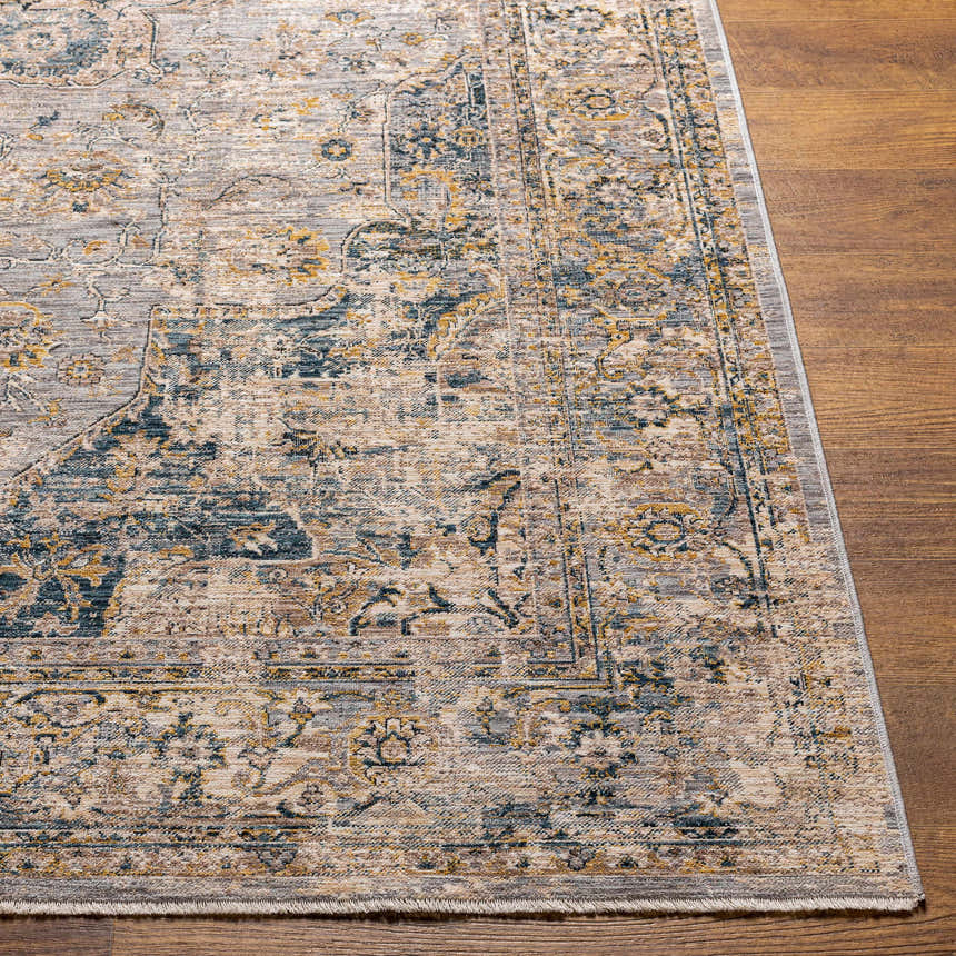 Close-up of the Tuganay Luxe Performance Rug. Beige, blue, and mustard tones in a traditional, distressed pattern. Front