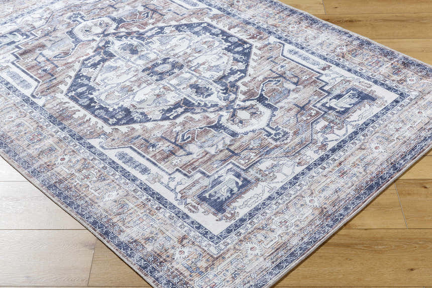 Close-up of Terri Washable Area Rug in beige, black, cream, dark red and gray with a traditional pattern. Corner
