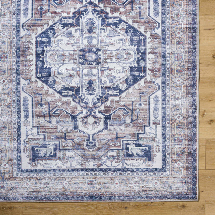 Close-up of the Terri Washable Area Rug showing its traditional beige, blue, and red pattern and soft texture. Corner
