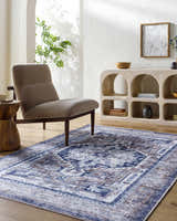 Living room scene with Terri Washable Area Rug in beige, black, and blue. Farmhouse style with chair and wood accents. Roomscene-Rectangle