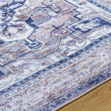 Close-up of Terri Washable Area Rug showing traditional beige, black, cream, and dark red pattern. Texture