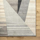 Close-up of the Toril Modern Wool Rug featuring a geometric design in ash, onyx, sage, and silver gray. Swatch