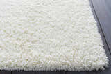 Close-up of the cream Umpire Area Rug. This shag rug has a soft, textured pile and is hand woven. Styleshot
