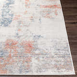 Close-up of Upminster Area Rug showing brick red, charcoal, and light beige abstract pattern and machine woven texture. Front