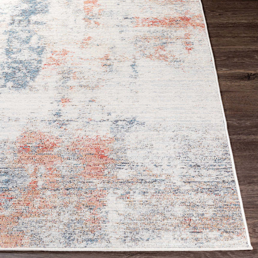 Close-up of Upminster Area Rug showing brick red, charcoal, and light beige abstract pattern and machine woven texture. Front