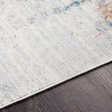 Close-up of the Upminster Area Rug showing its light beige base with brick red, teal, and charcoal accents. Texture