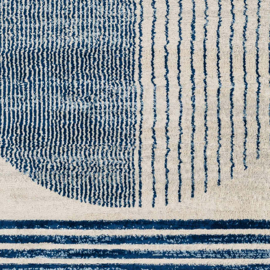 Close up of the Usra Area Rug featuring a blue and white geometric pattern. Swatch