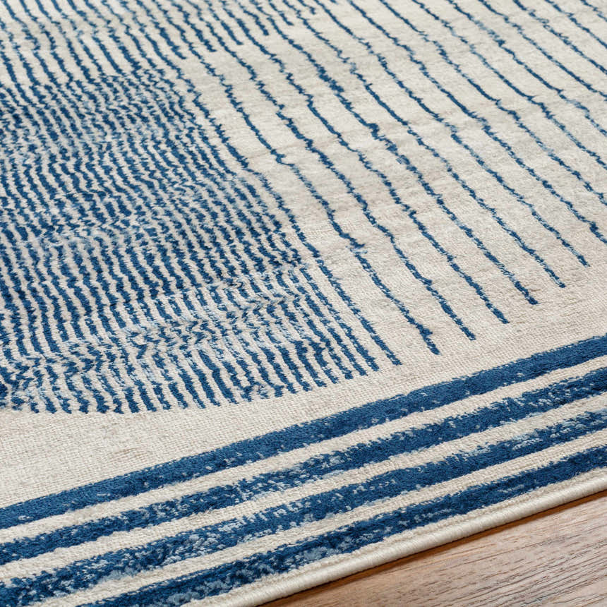 Close-up of the Usra Area Rug showing a geometric pattern in harbor blue and white on a textured surface. Texture