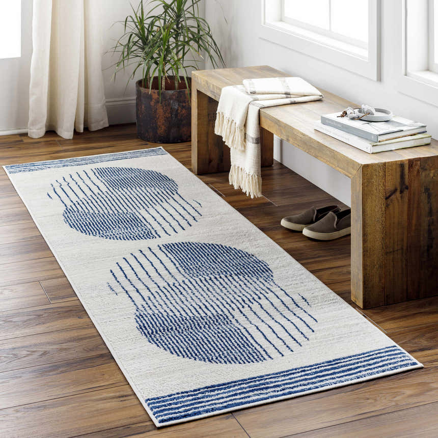 Entryway with wood floors, bench, and Usra Area Rug in white and blue geometric pattern. Roomscene-Runner
