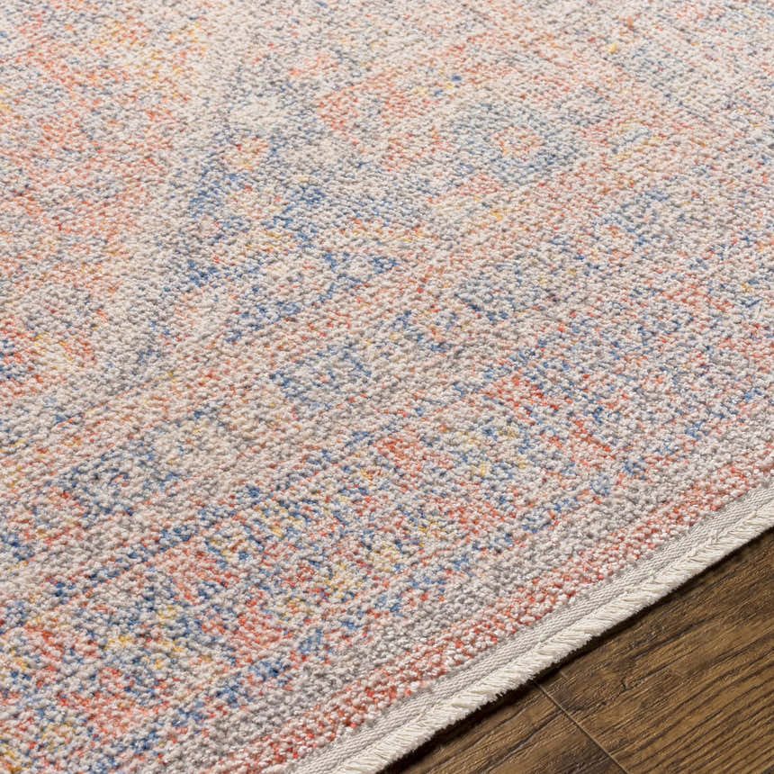 Close-up of the Vahn Area Rug showing its ivory base with dark blue, light pink, and mustard accents. Texture