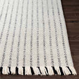 Close-up of the Varennes Area Rug showing its cream and black striped design, wool texture, and fringed edge. Front