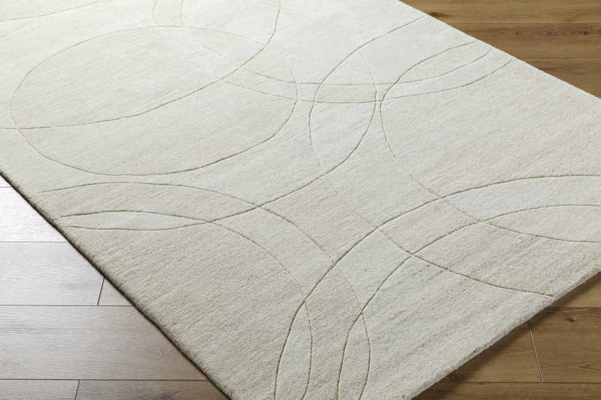 Close-up of the light silver Ville Modern Wool Rug showing its contemporary circle pattern and soft, textured wool. Corner