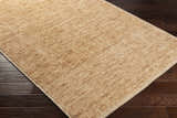 Close up of the hand-loomed Vezirhan Area Rug in peach and dark red, showcasing texture and construction. Corner