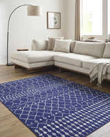 Living room scene with a blue Varun Area Rug, beige sectional sofa, and light wood floors. Roomscene-Rectangle