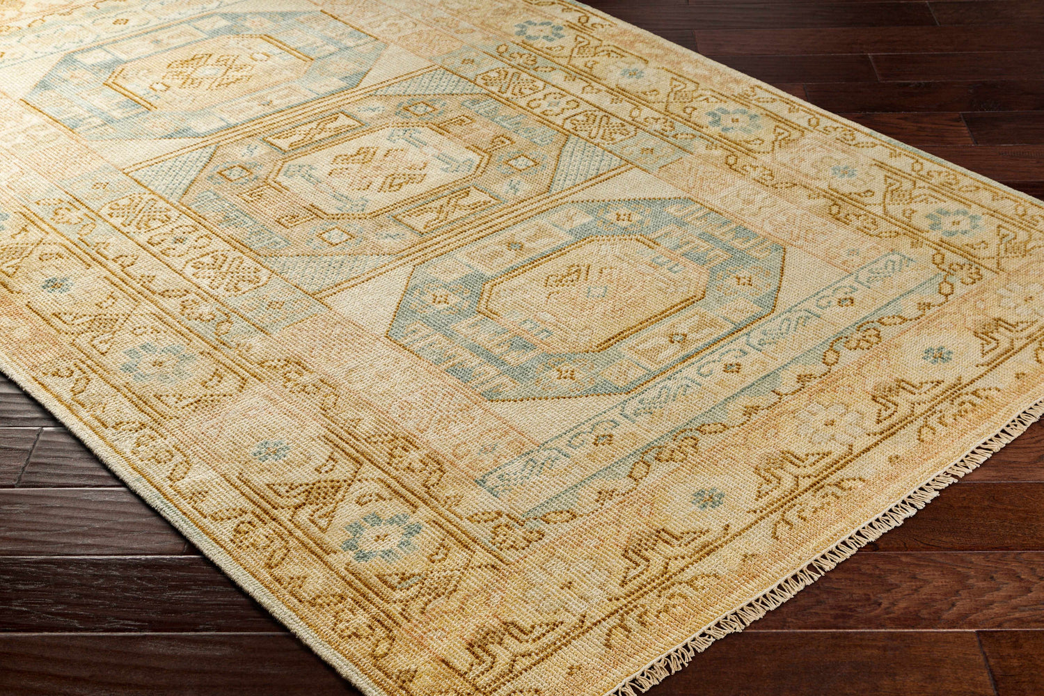 Close-up of the hand-knotted Villareal Area Rug, a traditional design in cream, beige, and ice blue on dark wood floors. Corner