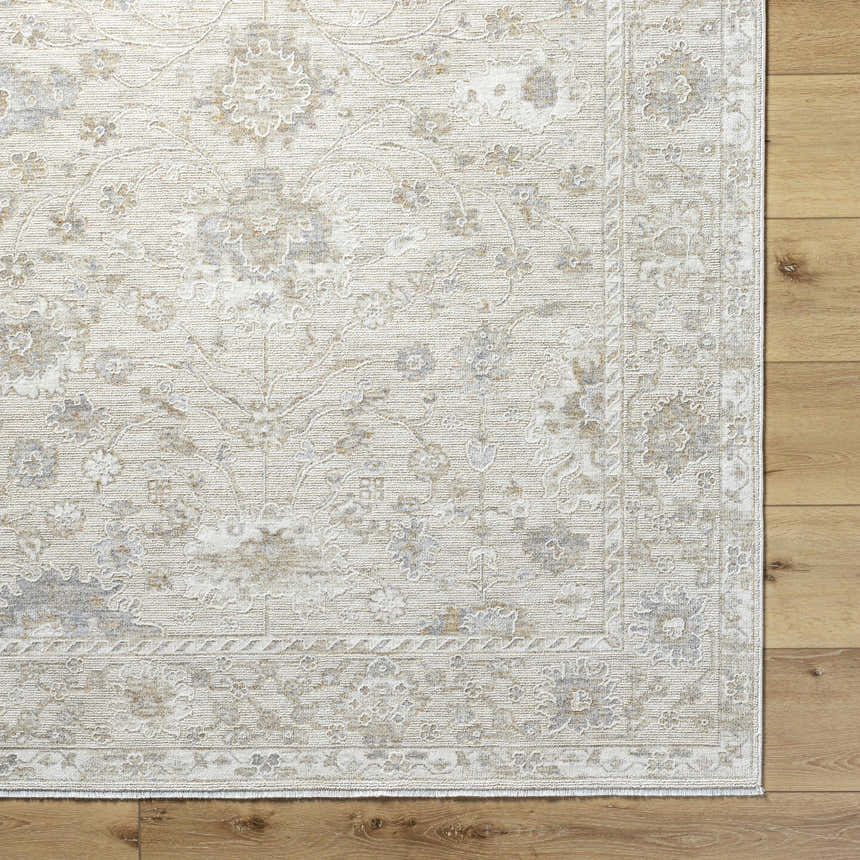 Close-up of the Vaman Luxe Rug in light silver and sterling gray, featuring a traditional floral pattern. Corner