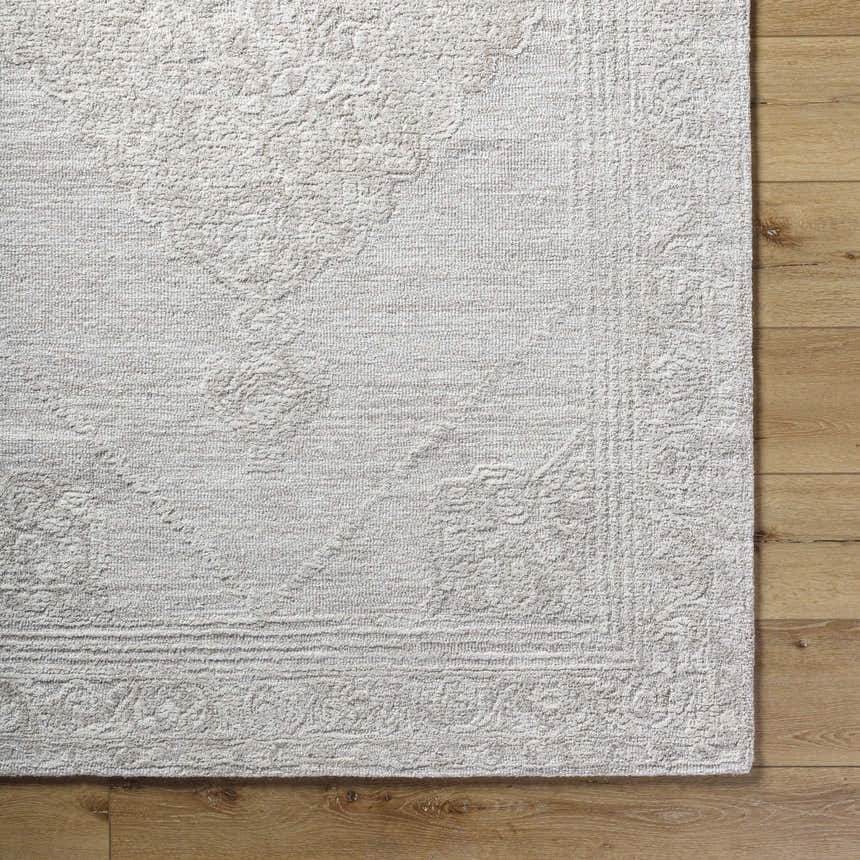 Close up of the hand tufted Verne Area Rug in ash, showing the wool texture and traditional pattern. Corner