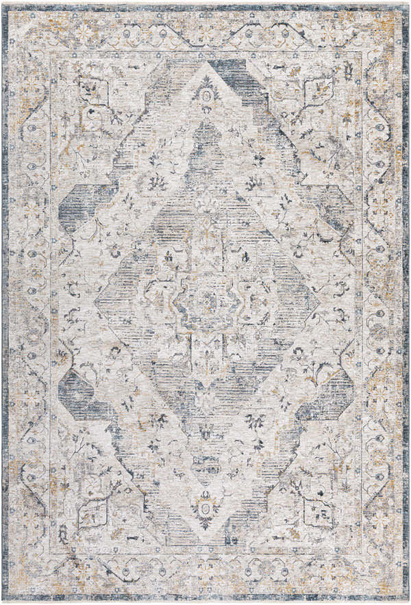 Close-up of the Wadeye Luxe Fringe Rug, a machine-woven rug with a traditional pattern in dark blue, gray, and mustard tones. Design-Rectangle-6796