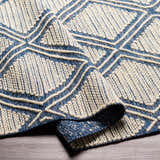 Close-up of the Walgett Area Rug. Hand-woven cotton rug in blue and cream with a geometric diamond pattern. Farmhouse style. Fold