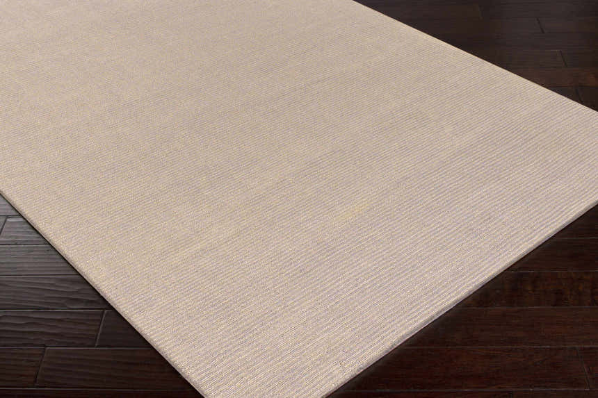 Close-up of the Brockton Solid Tan Rug showing its subtle striped texture and hand-loomed wool construction. Corner