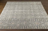 Close-up of the hand-knotted Woodsfield Premium Rug. Beige, brown, and gray geometric pattern. Wool texture. Front